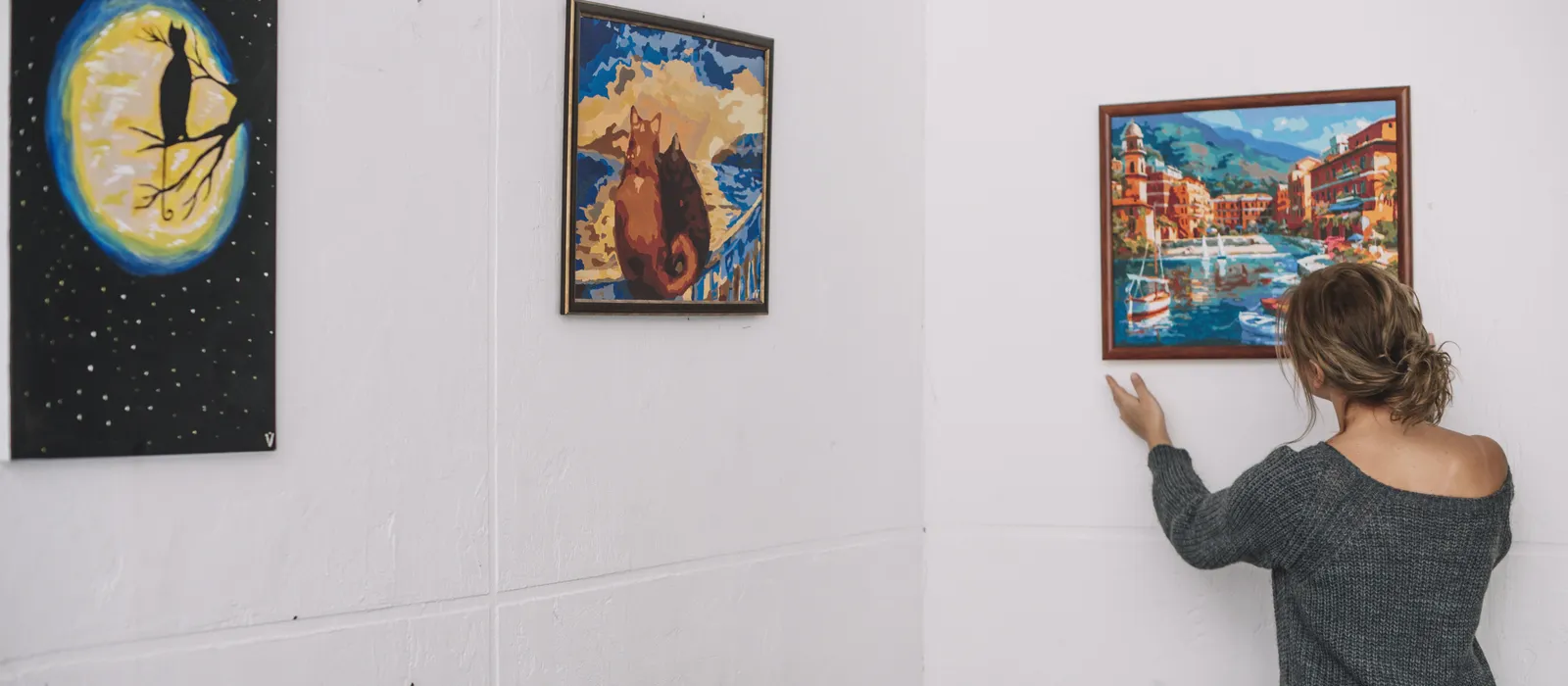 1765819375-woman-placing-picture-wall