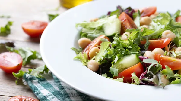 1766585056-healthy-chickpea-salad-with-tomatolettuce-cucumber-wooden-table