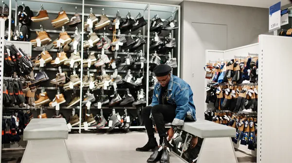 1767968791-stylish-casual-african-american-man-jeans-jacket-black-beret-clothes-store-trying-new-footwear