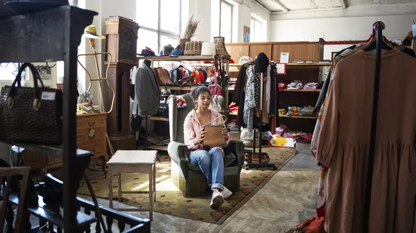 1769856834-woman-sitting-thrift-shop-full-shot