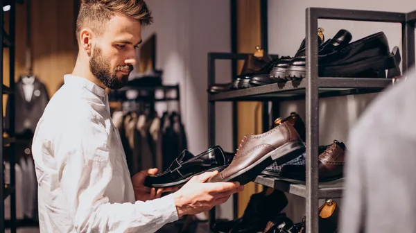 1770973265-man-choosing-foot-wear-mens-store