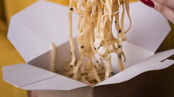 1769096447-woman-holding-noodles-chopsticks