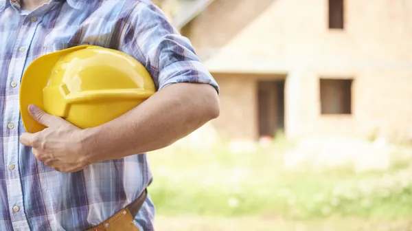 1776761875-close-up-man-holding-his-head-protector-outdoors