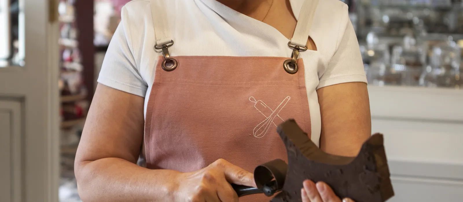 Female confectioner with chocolate pastry shop