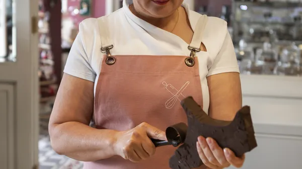 Female confectioner with chocolate pastry shop