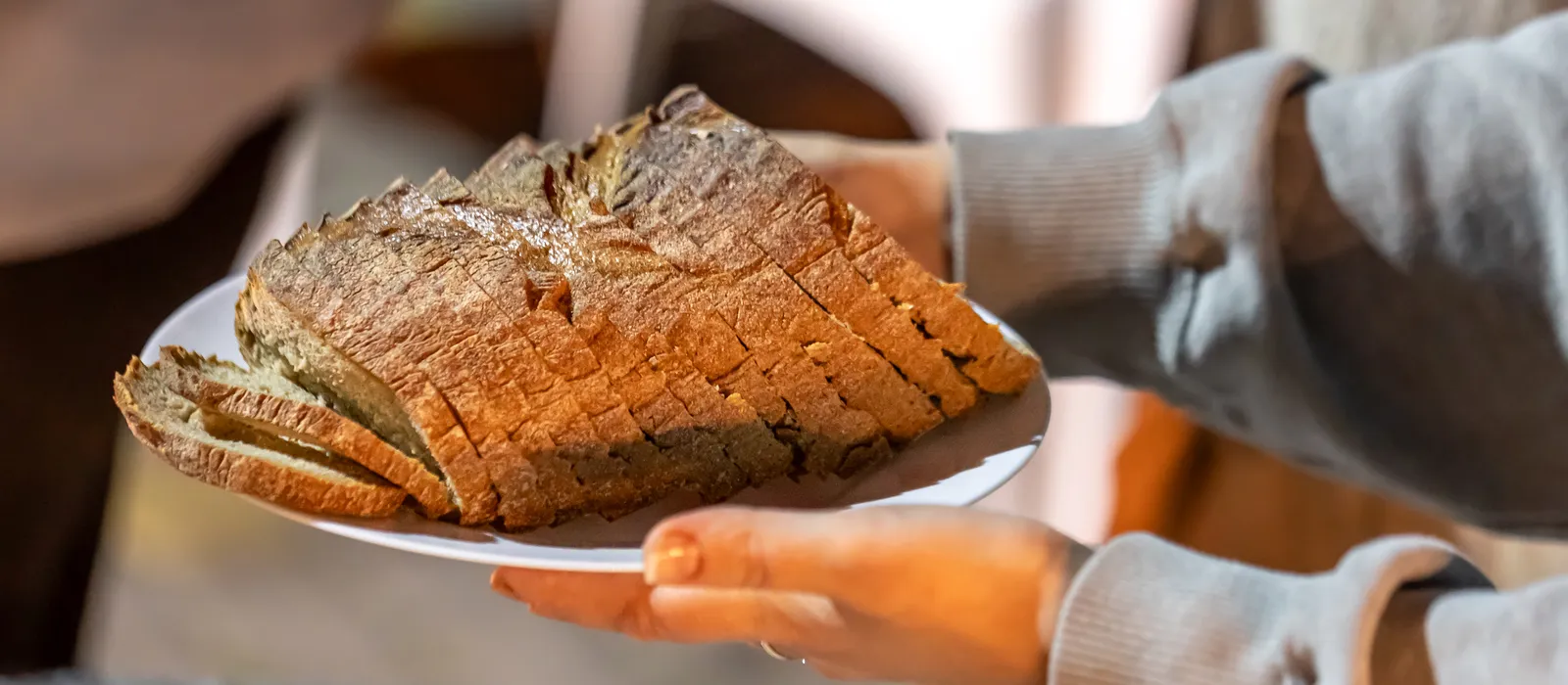 Plate with sliced bread female hands