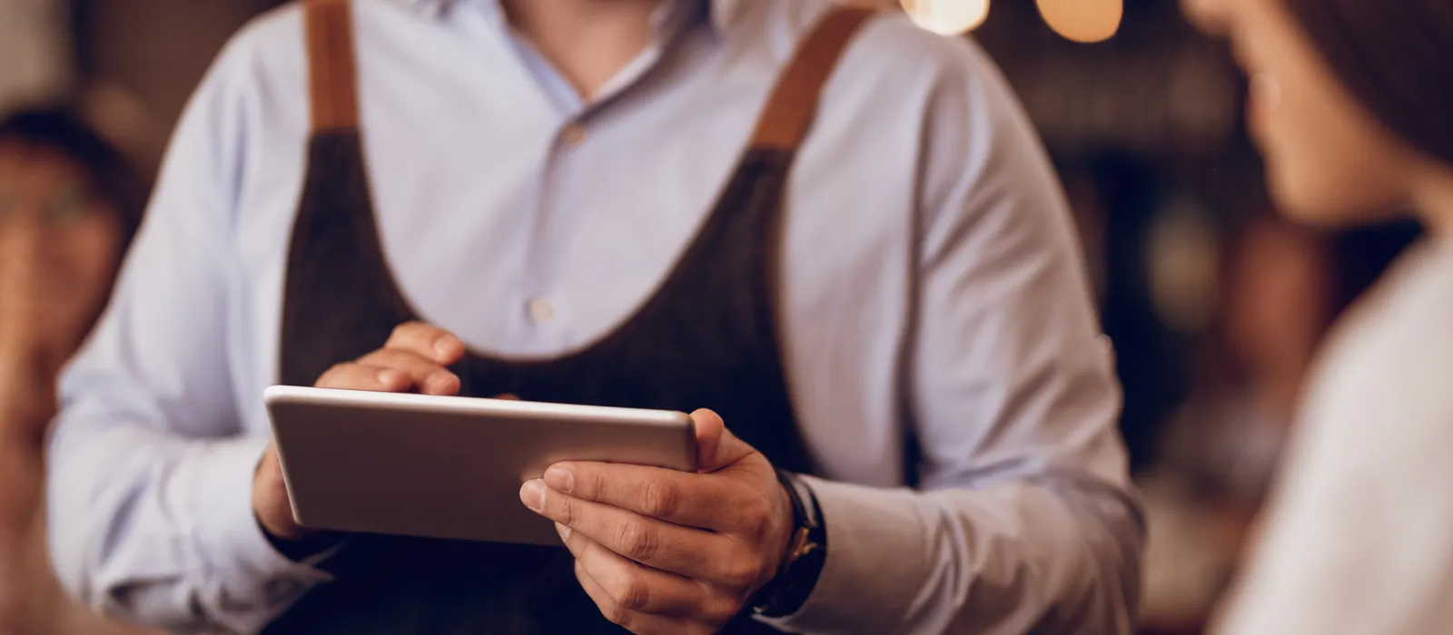 Closeup waiter taking order touchpad while talking guest pub
