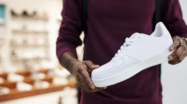 African man holding white sneaker