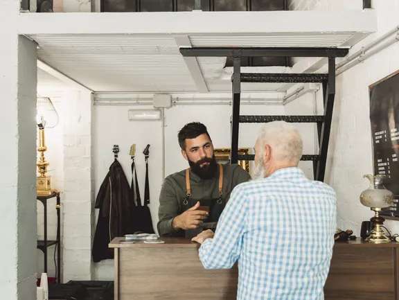 Barber talking with client reception desk