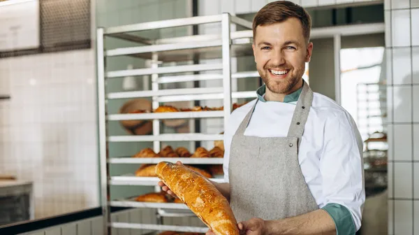 Man baker with fresh bread baker house