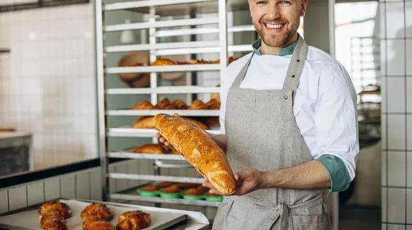 Man baker with fresh bread baker house