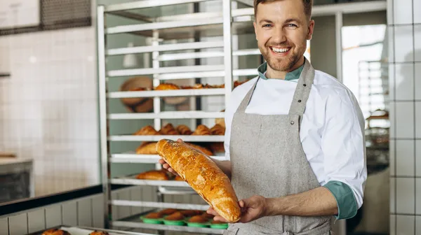 Man baker with fresh bread baker house