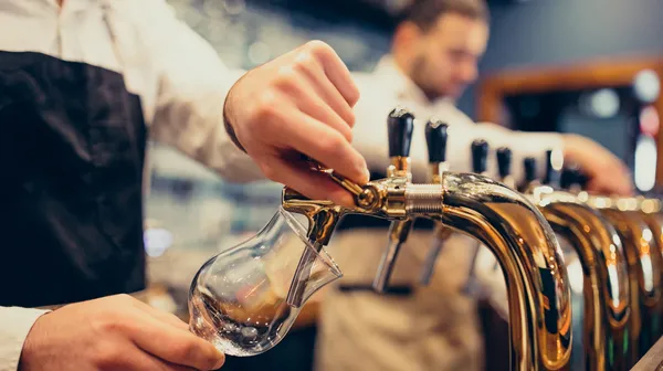 Two handsome bartenders poring beer pub